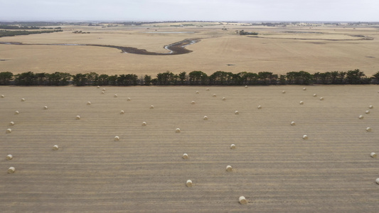 区域澳洲的一个农场上滚干草篮的空中录像视频