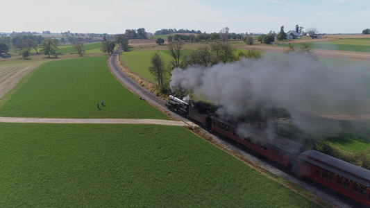 古董的空中风景恢复蒸汽机车载客汽车在农村行驶吹黑烟视频