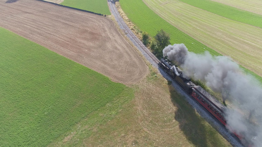 古董的空中风景恢复蒸汽机车载客汽车在农村行驶吹黑烟视频