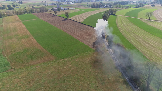 古董恢复蒸汽机的空中风景该蒸汽机在田地上飘散烟雾视频