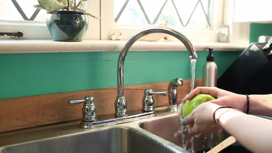 十几岁的女孩在厨房水槽里洗苹果视频