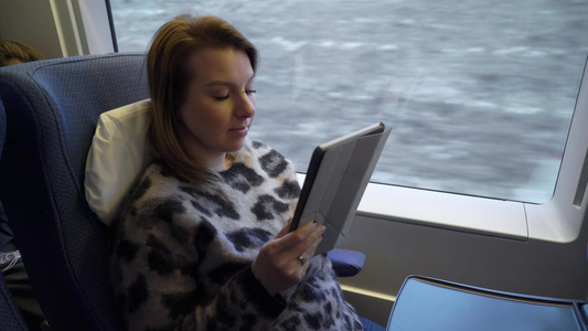 女青年在一辆火车车上工作手持平板电脑视频