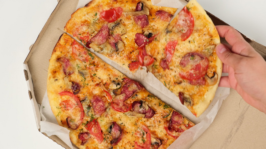 用奶酪西红柿香肠和蘑菇烤圆环披萨在白纸箱中切成碎片视频