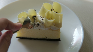 用手勺切美味的白巧克力蛋糕甜甜点放在白色盘子上自制10秒视频