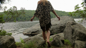湖边岩石上脱衣服比基尼的女人29秒视频