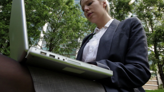 在城市公园用笔记本电脑工作的女商人视频
