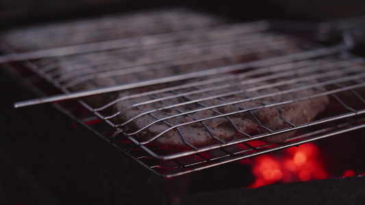 在烧烤木炭的网格中煮猪肉视频