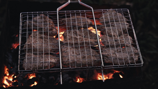 在烧烤木炭的网格中煮猪肉视频