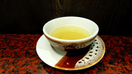 桌子上的白瓷杯子上汤的热量产生的烟雾视频