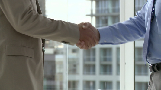 两个商人在办公室握手特写视频