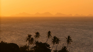雄伟的热带橙色夏季海上实时日落与山脉剪影在海洋中的14秒视频