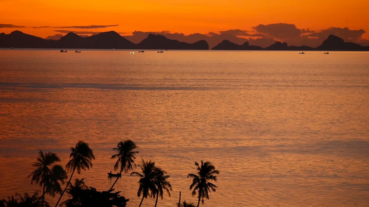 雄伟的热带橙色夏季海上实时日落与山脉剪影在海洋中的视频