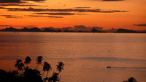 雄伟的热带橙色夏季海上实时日落与山脉剪影在海洋中的18秒视频