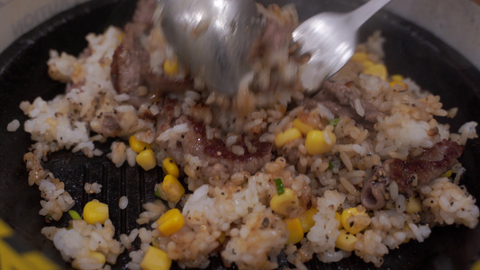 热锅里装有牛肉和玉米泉洋葱的炒米饭日式牛肉或猪肉菜视频