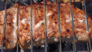 美味的多汁猪肉牛排在木炭烧烤炉上用含火烟的金属叉子11秒视频