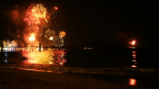 明亮的金烟花在海面上空的夜空中爆炸视频