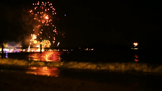 明亮的金烟花在海面上空的夜空中爆炸视频