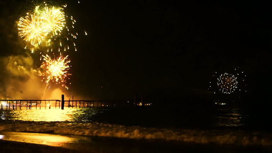 明亮的金烟花在海面上空的夜空中爆炸视频