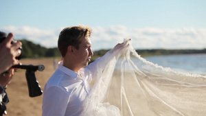 摄影记者拍摄手挥新娘面纱的照片11秒视频