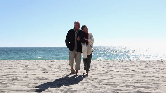 成熟的情侣手挽手走在沙滩上视频