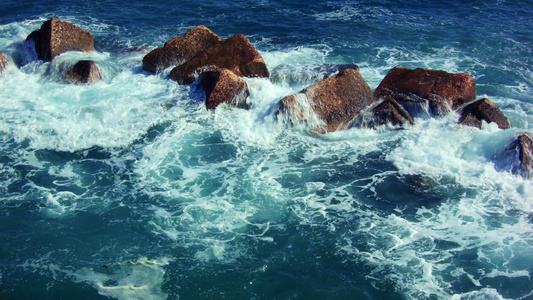 深绿色海浪在深红岩石上坠落视频