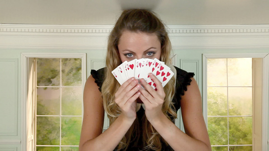 年轻女子在小房间里玩手纸牌视频