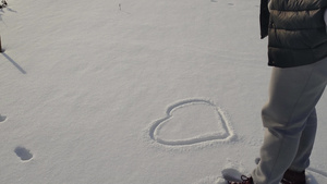 女人在冬天雪白雪上画了一颗心5秒视频