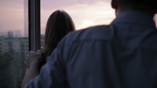 日落时阳台上的年轻夫妇视频