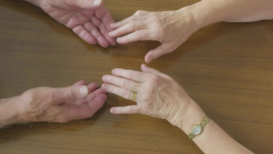 一对手握手的高级天主教夫妇的顶端视图视频