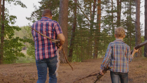 父亲和儿子在森林中背着木柴23秒视频