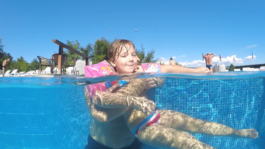 有趣的小女孩在热水池里和父亲一起玩得开心她从嘴里吐舌头视频