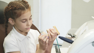 一个好奇的女孩在牙医办公室看口腔模型10秒视频