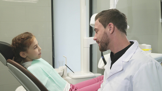 可爱的牙医与他的年轻病人交谈视频