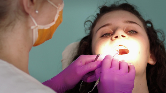 牙科牙医对少女用紫外线照明灯填充瓷器视频