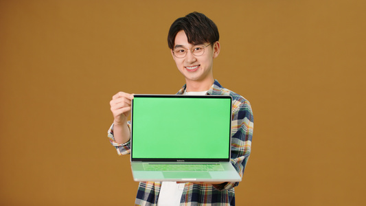 男青年展示笔记本电脑绿幕视频