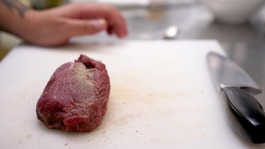 近身的烹饪手调制一块生牛肉肉视频