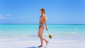 沙滩上拿着椰子的女人15秒视频
