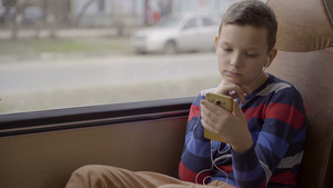 一个小男孩在汽车上玩手机24秒视频