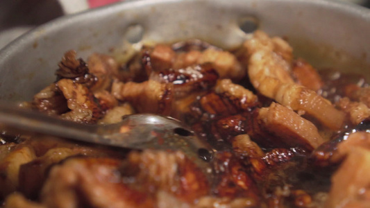 有人用勺子来搅拌牛排猪肉泡在锅上混合棕色酱汁慢动作视频