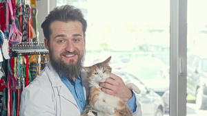 友好的兽医笑着对着镜头微笑手里有一只可爱的暴躁猫8秒视频