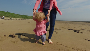 母亲带着女儿在海滩上散步9秒视频