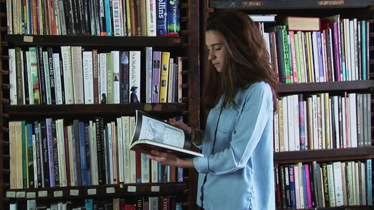 年轻女孩从书架上拿书进行查看视频