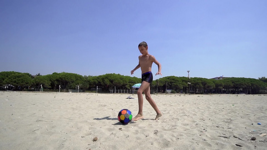 日落时在海滩上玩儿小孩的乐趣以慢动作踢足球电影视频