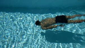 年轻的运动男子与健美的身体在水晶般清澈的水游泳池中11秒视频