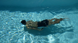 年轻的运动男子与健美的身体在水晶般清澈的水游泳池中12秒视频