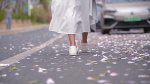 4K少女漫步在飘满花瓣的道路上脚部特写16秒视频