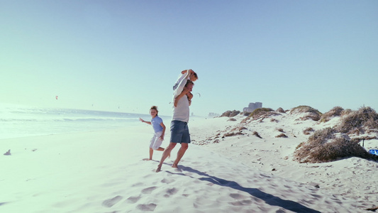 父亲带着儿子在海滩上玩耍视频