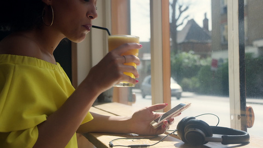 玩智能手机喝果汁的女人视频