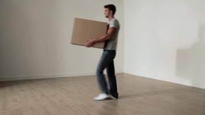 男人抱着纸板箱穿过空荡荡的房间9秒视频