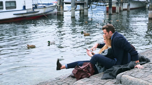 坐在湖边使用智能手机的年轻情侣11秒视频